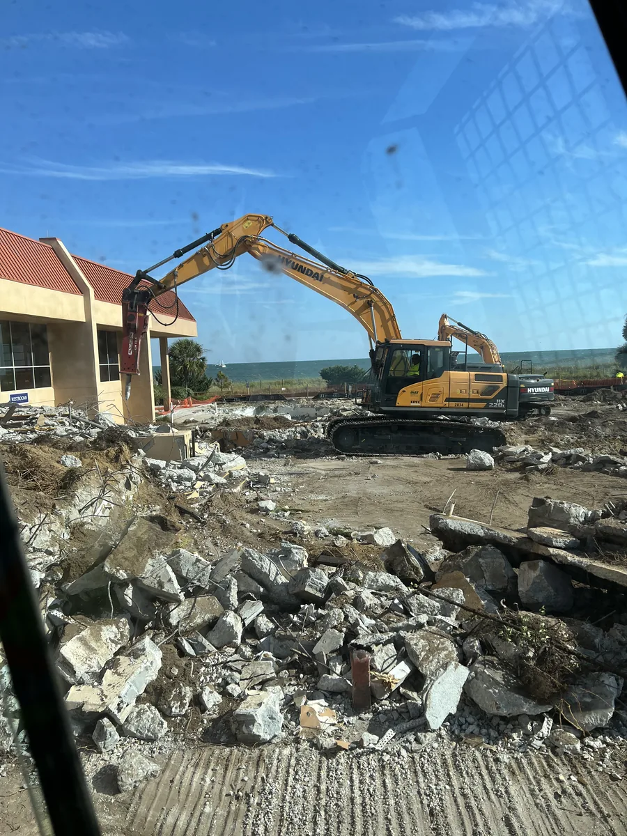 Excavator removing concrete and foundation debris