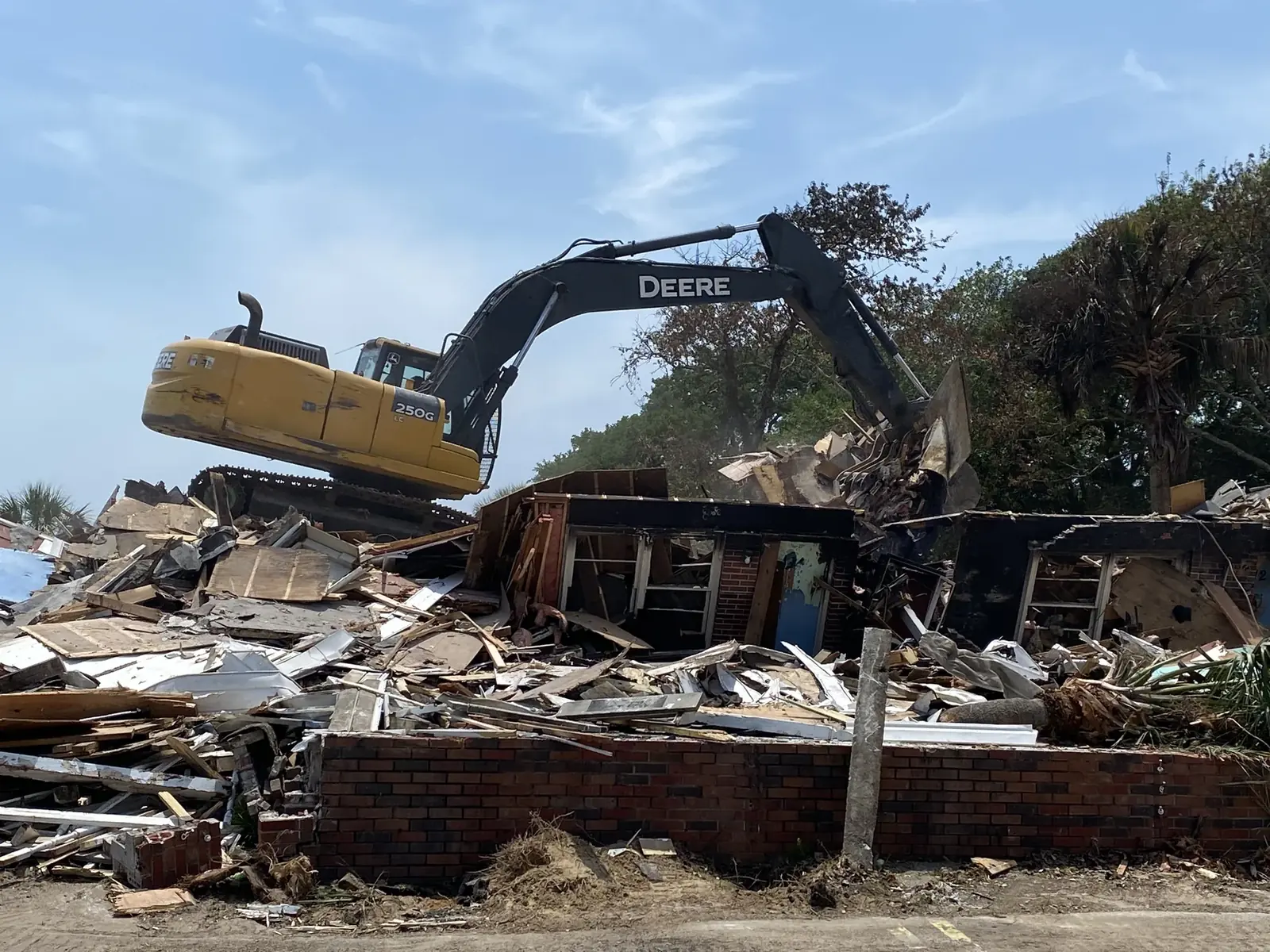 John Deere excavator performing structural demolition