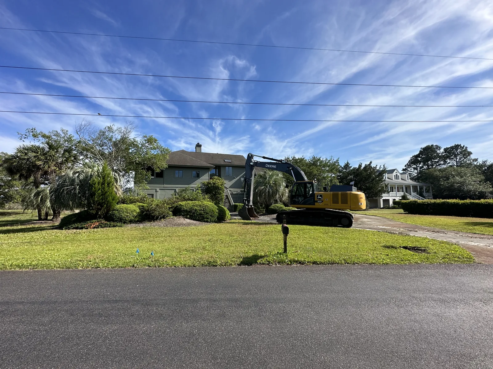 Excavator beginning removal of a house