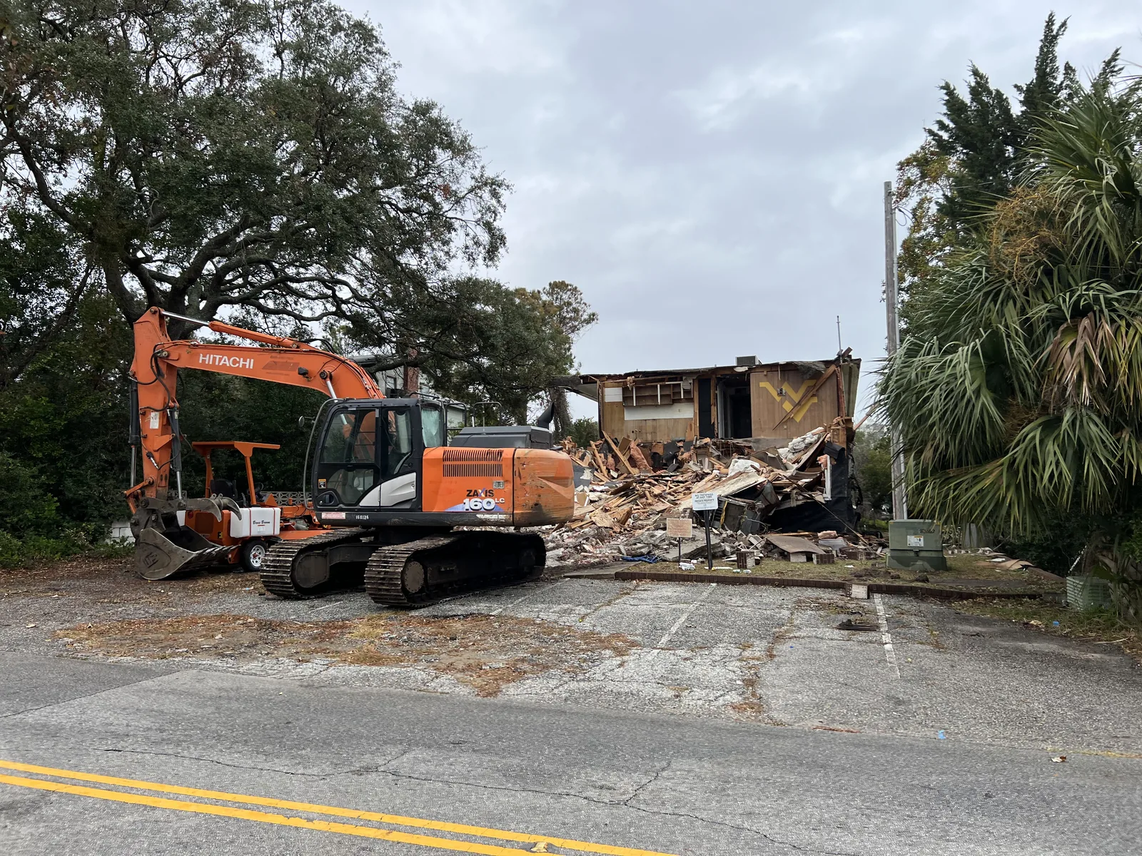 Excavator demolishing a residential structure