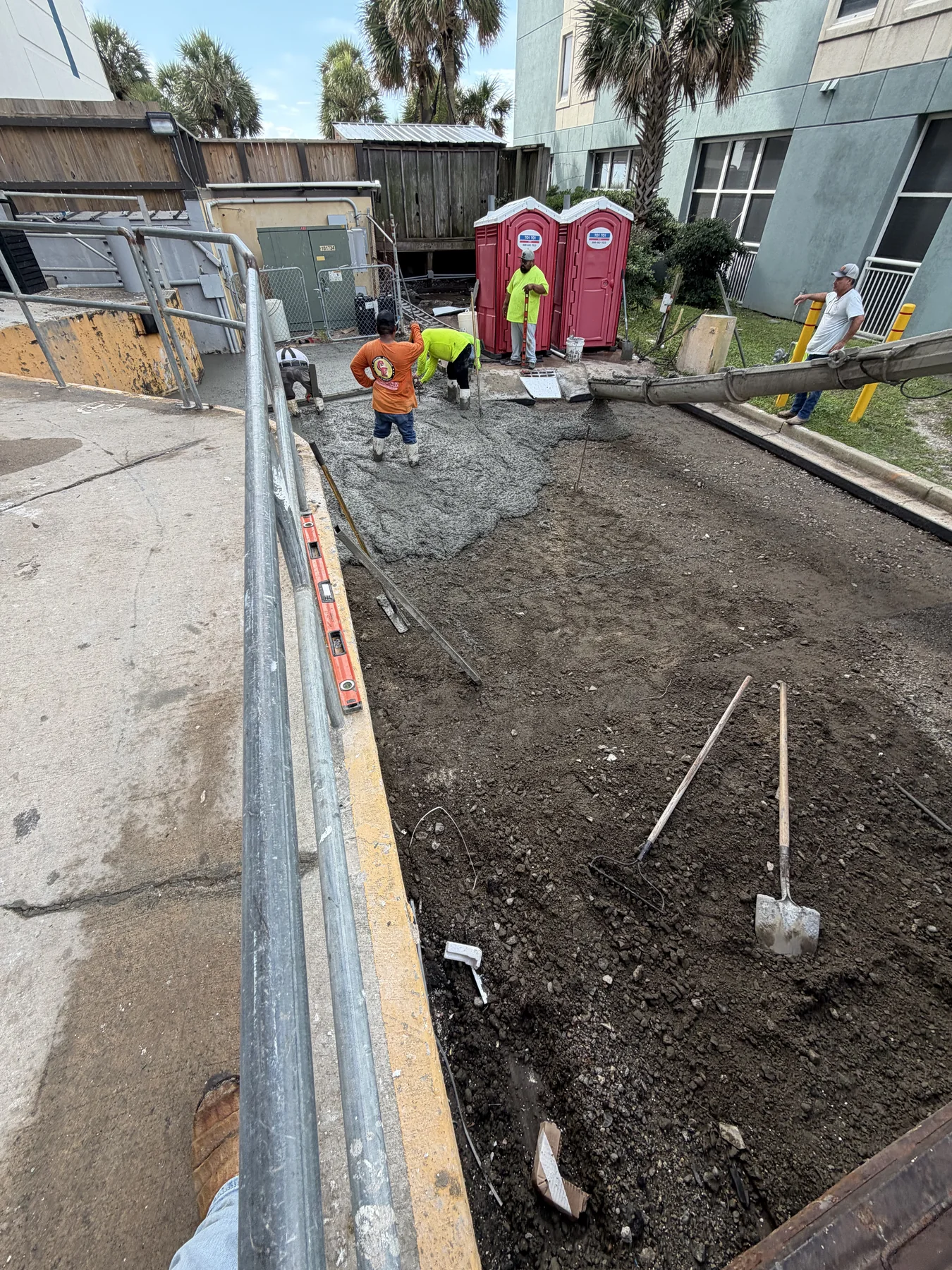 Crew placing and finishing concrete paving at a commercial site